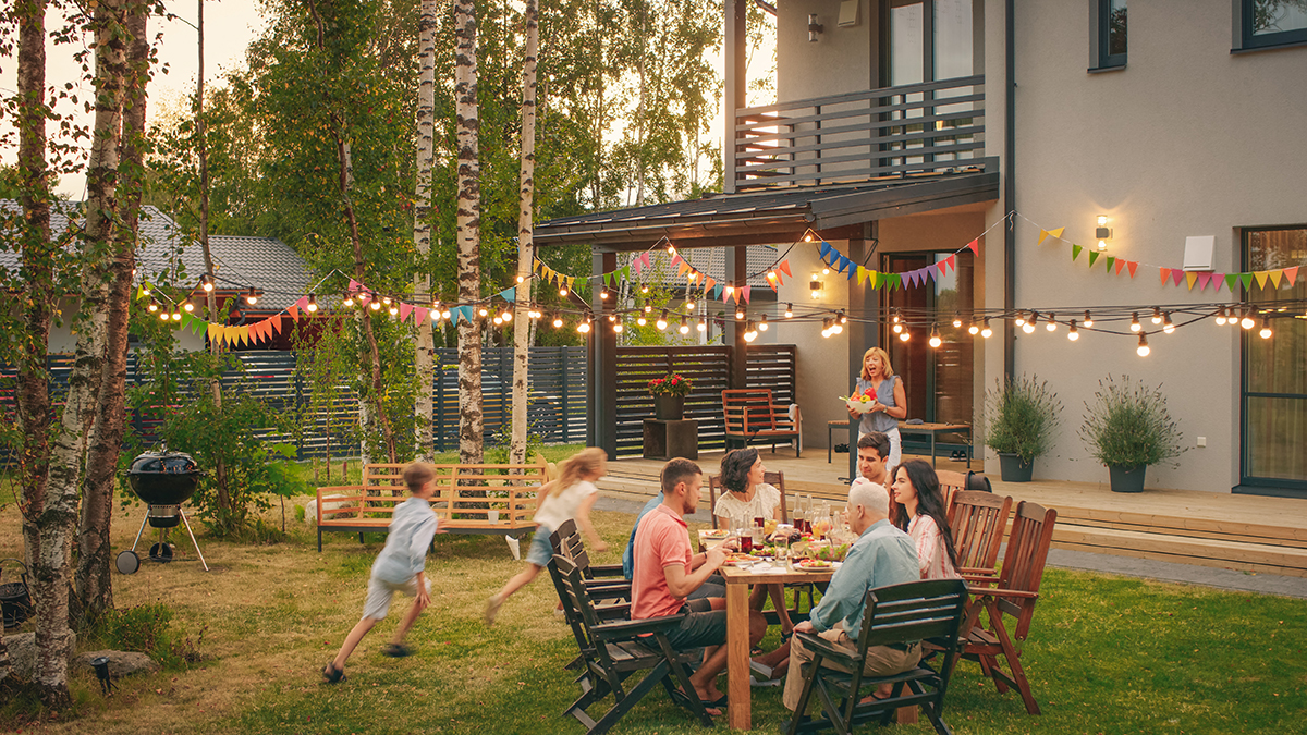 a big family eating a meal in a backyard