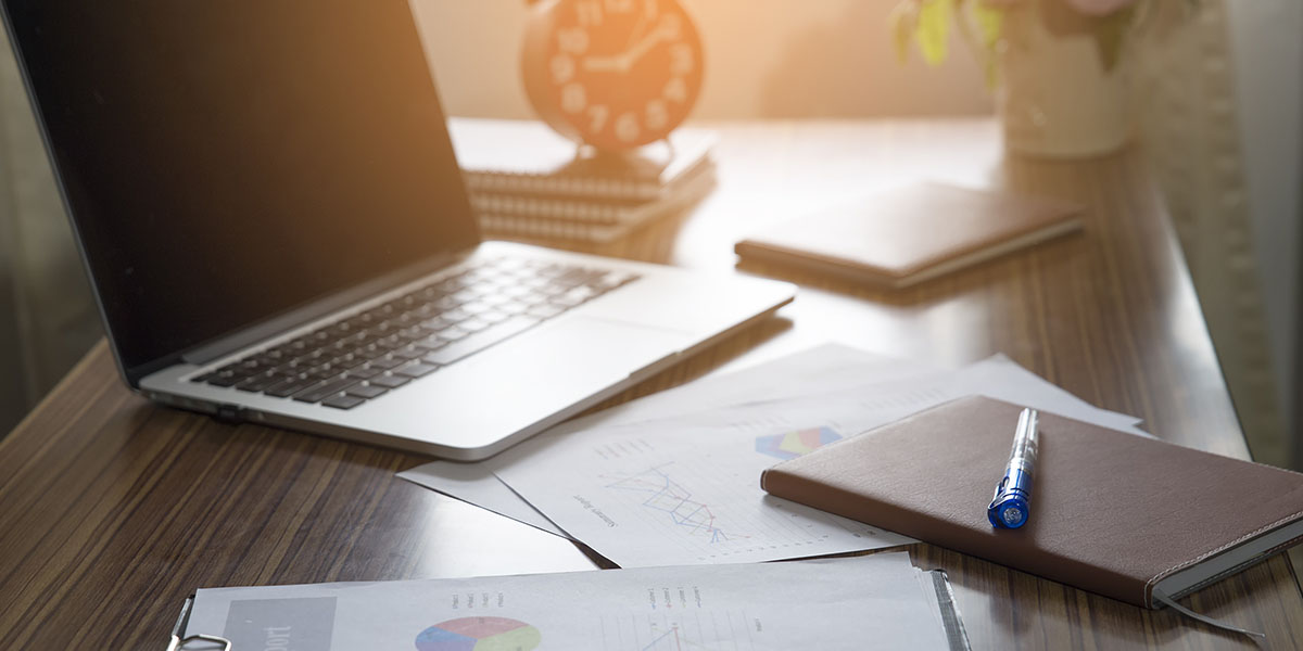 laptop and papers sitting on a desk