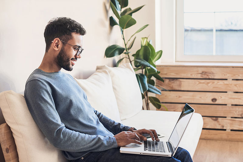 Man sitting on couch with laptop